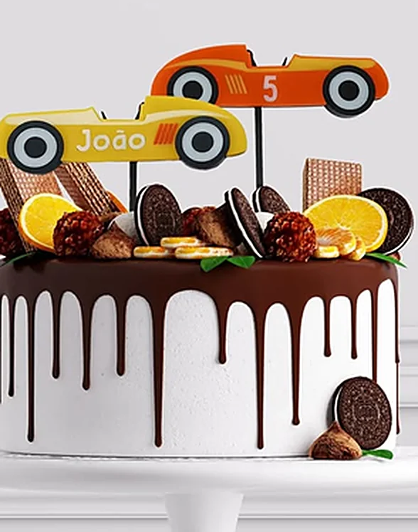 Birthday cake topped with two colourful acrylic racing cars, one with a name and one with the number five.